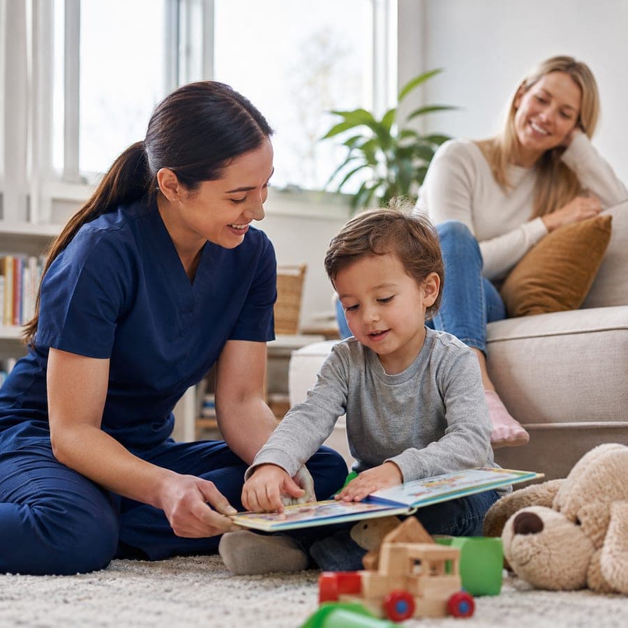 A caregiver reading with a child while a parent looks on